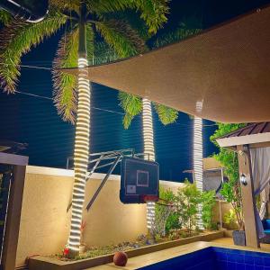 un patio avec un panier de basket et un palmier dans l'établissement Palazzo de Amor Private Resort, à Pansol