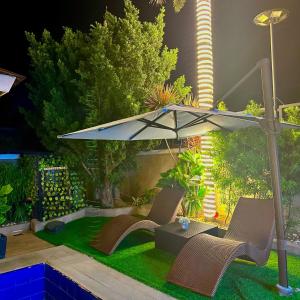 un patio avec deux chaises et un parasol dans l'établissement Palazzo de Amor Private Resort, à Pansol