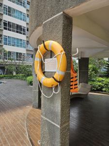 an orange life saving ring on the side of a building at Green Sedayu Apartment Family Suite by Ellison in Jakarta