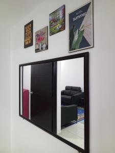 a mirror hanging on a wall with a black frame at Kijal Homestay in Kemasik +24 photos