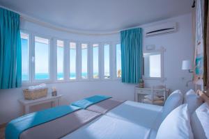 a bedroom with a large bed with blue curtains at Villa Sonia in Hersonissos