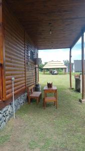 a pavilion with two benches and a table and a grill at Cabañas KAPO TEAM in Villa Amancay
