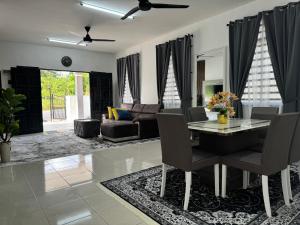 a living room with a table and a couch at Homestay White Aqil in Kampong Paya Pulai