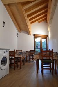 a dining room with tables and a washing machine at Villa de Salas Alojamientos in Salas
