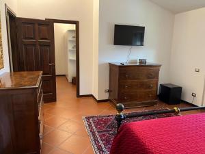a bedroom with a bed and a dresser with a television at Villa Amalia in Montalto Uffugo