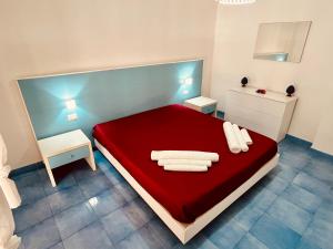 a bedroom with a red bed with towels on it at Licinio's Apartments - Casa Lavanda in Pantelleria