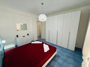 a bedroom with a red bed and white cabinets at Licinio's Apartments - Casa Lavanda in Pantelleria