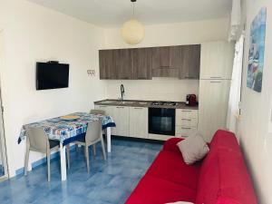 a living room with a red couch in a kitchen at Licinio's Apartments - Casa Lavanda in Pantelleria