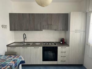 a kitchen with wooden cabinets and a stove and a sink at Licinio's Apartments - Casa Lavanda in Pantelleria