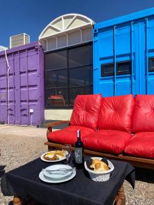a red couch and a table with food and a bottle of wine at Hotel en Ruta in Fiambalá +13 photos