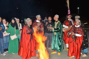 a group of people standing around a fire at Riad Dia in Marrakesh