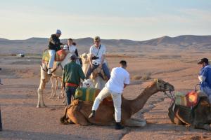 a group of people riding camels in the desert at Riad Dia in Marrakesh