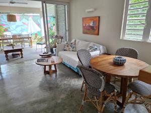 a living room with a couch and a table and chairs at Villa Ximun in Roches Noires