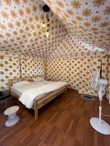 a bedroom with a bed and a ceiling with flowers at Yasnaya Camps in Bhowāli