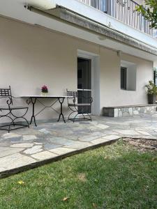 a patio with a table and chairs next to a building at Blue Pines in Péfka +4 photos