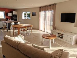 una sala de estar con un sofá y una mesa en L'Ancrage- 800m de la plage, en Brem-sur-Mer