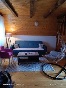 a living room with a blue couch and a table at Durmitorski cvijet in Žabljak