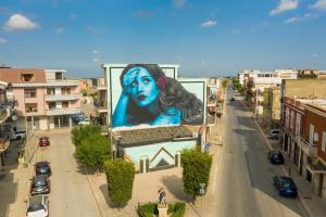 a large painting of a woman on the side of a building at Al 33 Apartment in Stornara