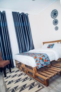 キガリにあるManna Stays, Kagaramaの青いカーテンが備わる客室で、ツインベッド2台が付いています。