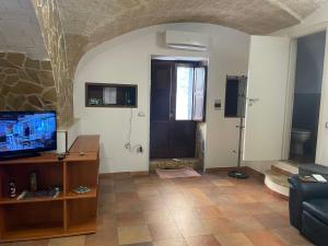a living room with a tv and a door at Casa Vacanza De Flagilla in Brindisi