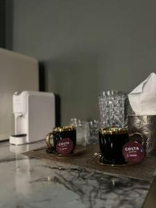 two coffee cups sitting on a counter next to a microwave at Offspa privátní wellness in Prague