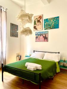 1 dormitorio con 1 cama con sábanas verdes y cuadros en la pared en B&B Casa Sant'Eufemia, en Módena