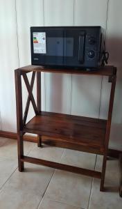 a microwave sitting on top of a wooden stand at Magnolia azul in Federación