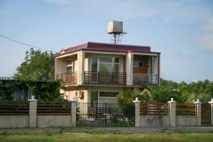 a house with a fence in front of it at Magnito in Shekvetili