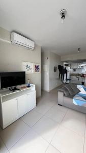 a bedroom with a bed and a television and a table at Apartamento New Wave - 2 quartos Setor Bueno in Goiânia