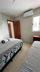 a bedroom with two beds and a window at Apartamento New Wave - 2 quartos Setor Bueno in Goiânia