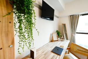 HakataNew! Japandi 203 1BR in Prime Location-1 min to Station的客厅配有桌子和墙上的电视