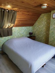 een bed in een kamer met een houten plafond bij Maison de vacances à Portsall in Portsall