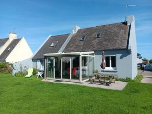 een huis met een serre met een tafel en een parasol bij Maison de vacances à Portsall in Portsall