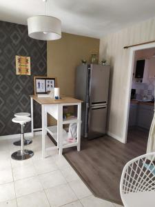 een keuken met een koelkast, een tafel en een aanrecht bij Maison de vacances à Portsall in Portsall