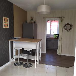 een keuken met een tafel en krukken in een kamer bij Maison de vacances à Portsall in Portsall +10 foto's