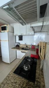a kitchen with a stove and a counter top at Apartamento New Wave - 2 quartos Setor Bueno in Goiânia