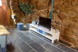 a living room with a tv on a white cabinet at Casa de Pombares in Veigas