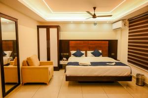 una camera da letto con un letto grande e una sedia di Manhas Olympus a Ernakulam