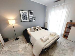 una camera da letto con un letto con lenzuola e cuscini bianchi di Domus Drea a Roma