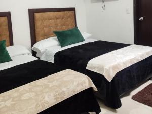 1 Schlafzimmer mit 2 Betten in Schwarz und Weiß in der Unterkunft Hotel Guadalupe Home in Pereira