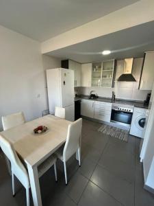 a kitchen with a table and chairs and a white refrigerator at Apartamento en Moncofa in Moncófar