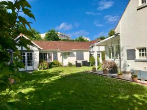 ein Haus mit einem grünen Hof in der Unterkunft Villa Barracuda in Le Touquet-Paris-Plage