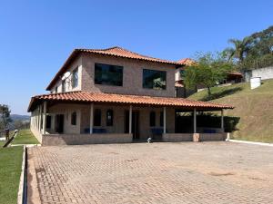 a house with a brick driveway in front of it at Recanto do Joao Sta Isabel in Santa Isabel