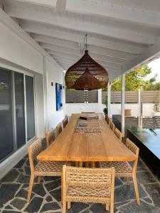 a dining room table with chairs and a chandelier at Evia Escape - Beachfront villa in Skála