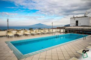 a swimming pool on the roof of a building with a view at HOTIDAY Room Collection - Sorrento in Sorrento