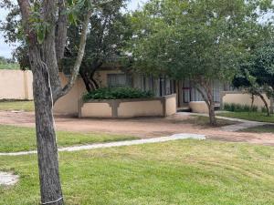 a building with trees in front of a yard at Soaring Summit Lodge in Ronaldsey