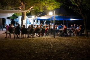 een menigte mensen die 's nachts aan tafel zitten bij Hotel Royal in Villammare