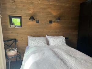 a bedroom with a bed in a wooden wall at Riverside Cottage in Lundur