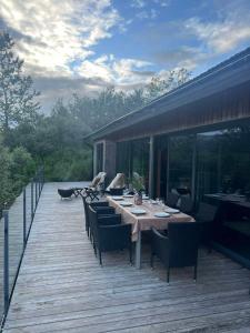 a wooden deck with a table and chairs at Riverside Cottage in Lundur