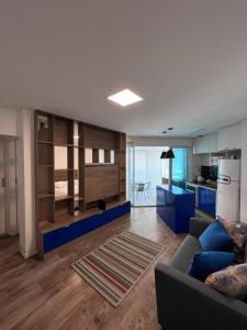 a living room with a couch and a kitchen at Unique Gonzaga Santos -Perto de tudo, 5min da praia in Santos